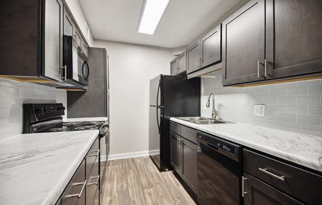 a kitchen with marble counter tops and black appliances at Shellbrook, Raleigh, 27609