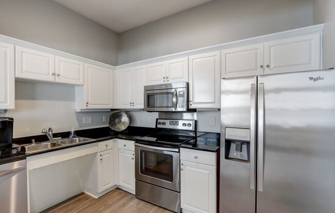 a kitchen with stainless steel appliances and white cabinets