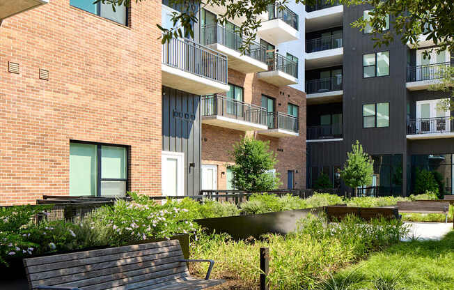 A park area with a bench and a building in the background.