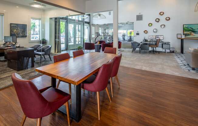 a dining room with a wooden table and red chairs