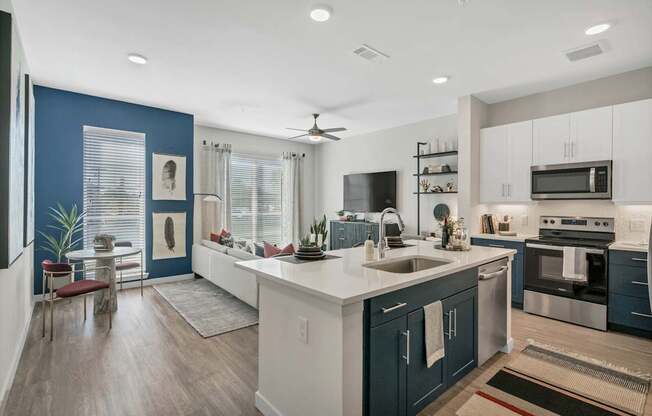 A modern kitchen with dark blue walls and white countertops.