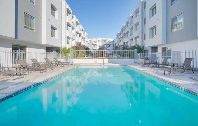 A swimming pool in front of apartment buildings at Woodley Sara Apartment, Van Nuys, CA, 91406