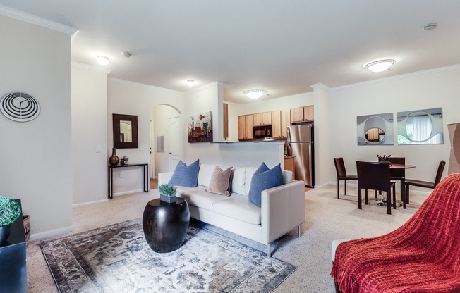 a living room with a white couch and a red chair at Plantation Crossing, Lafayette, LA, 70508
