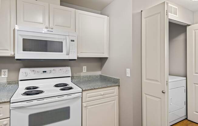 a kitchen with white appliances and white cabinets
