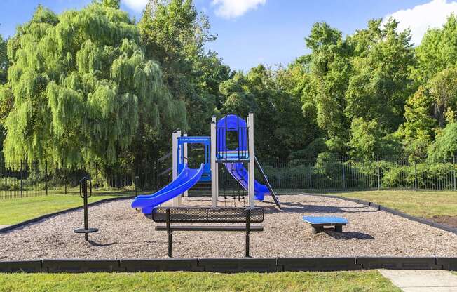 A playground with a blue slide and a blue and white structure.