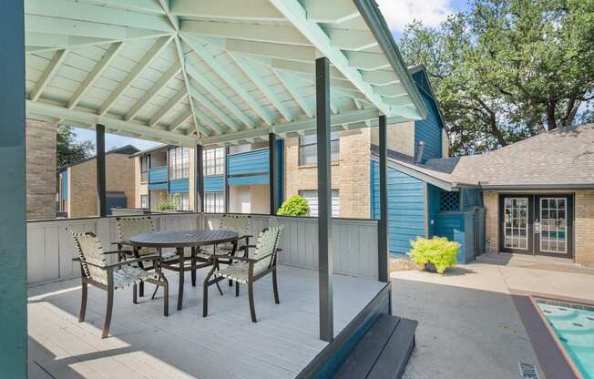 a patio with a table and chairs and a pool