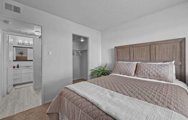 A bedroom with a large bed and a mirrored closet.