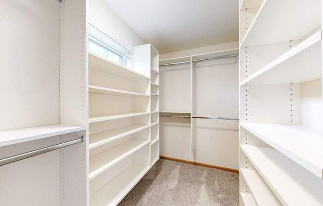 Empty white shelves in a room with a window.