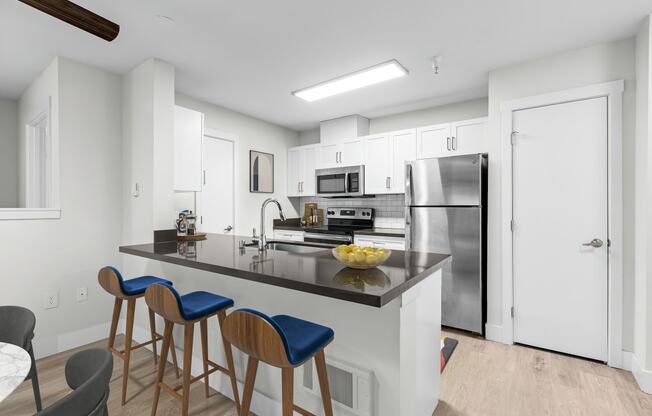 a kitchen with a large center island with a breakfast bar and three stools