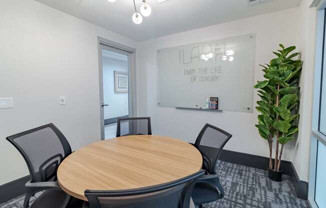 a conference room with a round table and a large potted plant