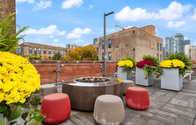 a fire pit on the roof of a building with colorful flowers