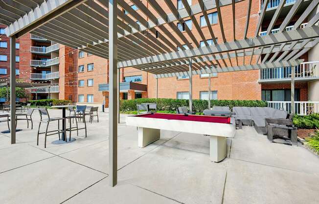 A patio with a table and chairs under a roof.