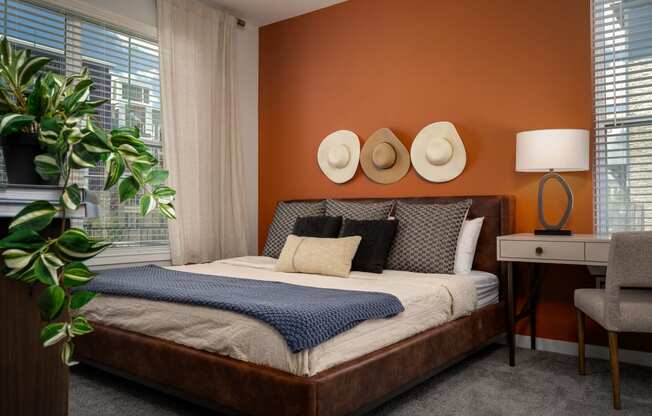 a bedroom with an orange wall and a bed with hats on it