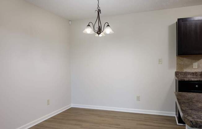 A room with a hanging light fixture and a counter.