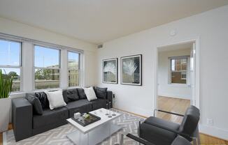 a living room with a black couch and a white coffee table