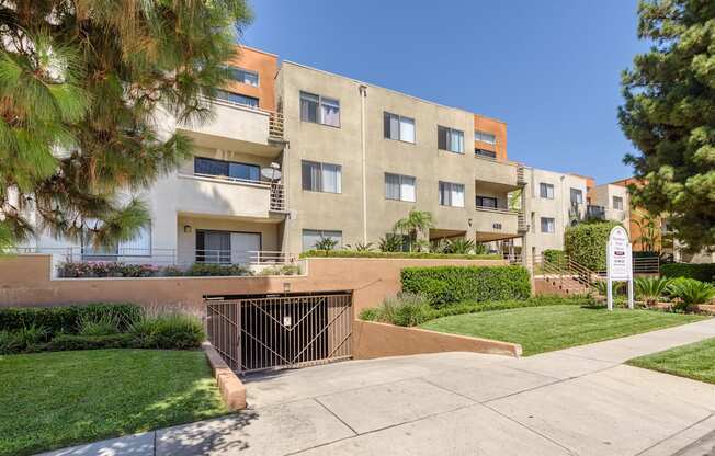 an apartment building with a gated entrance and a sidewalk