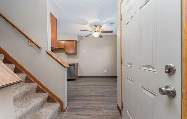 A hallway with a staircase and a door