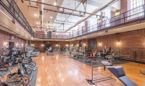 the gym atrium has a lot of exercise bikes and other fitness equipment