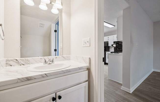 A bathroom with a marble countertop and a white sink.
