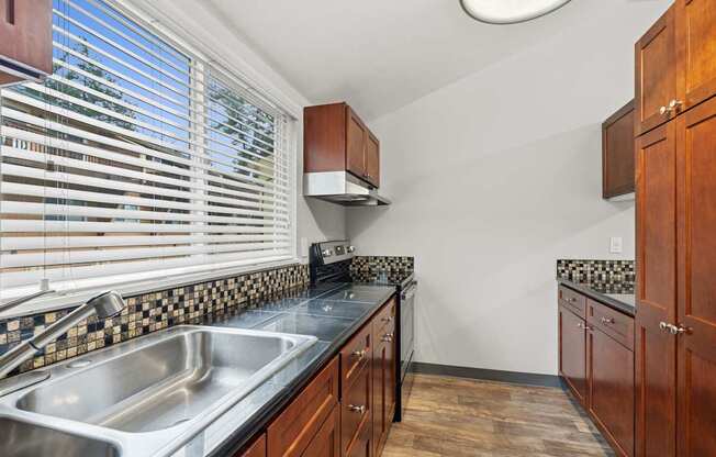 A kitchen with wooden cabinets and a black and white checkered backsplash.