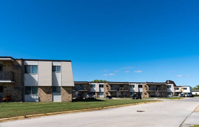 Apartment buildings on a street with a blue sky in the background at Parkwest Gardens West Fargo