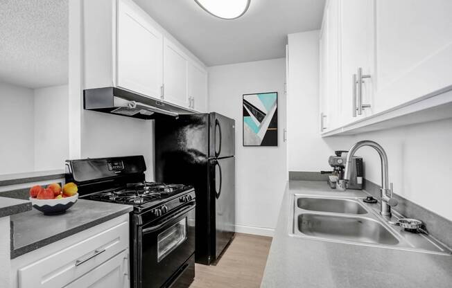 a kitchen with stainless steel counter tops and black appliances