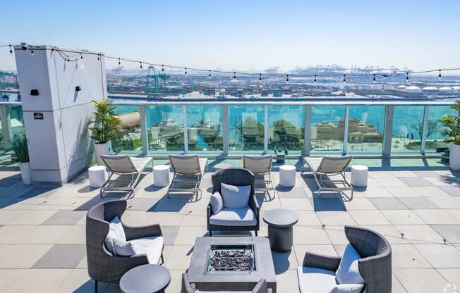 a rooftop patio with chairs and tables and a view of the city at Vue, San Pedro, CA 90731