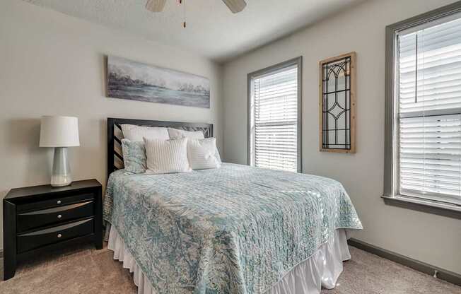 a bedroom with a bed and two windows