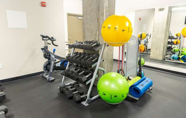 a fitness room with weights and a yellow ball in the middle of it