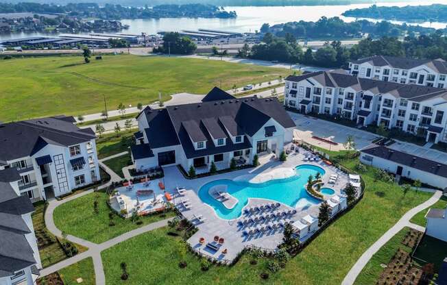 an aerial view of a large swimming pool in front of a house