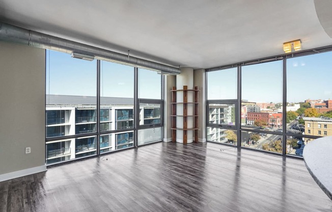 an open living room with windows and a view of a city