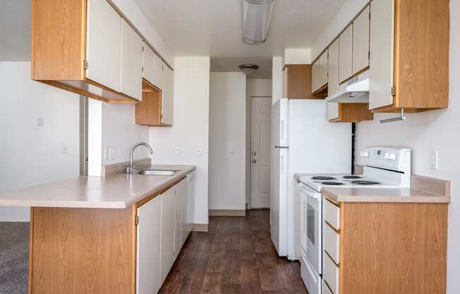 a kitchen with white appliances and wooden cabinets