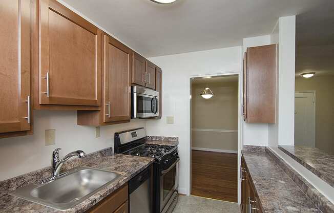 Partially renovated kitchen with stainless steel appliances at Mason Hall in Alexandria, VA 22314