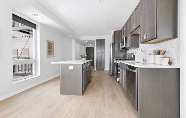 a kitchen with gray cabinetry and white countertops
