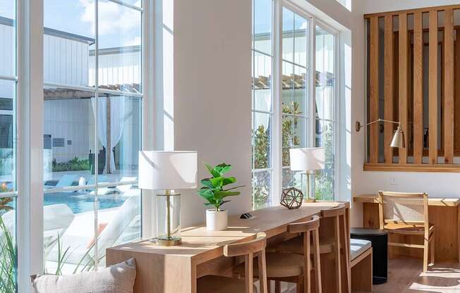 a room with large windows and a wooden table and chairs