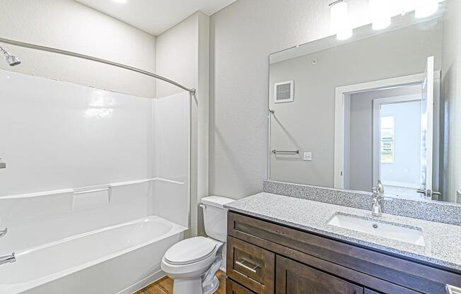 a bathroom with a sink toilet and a mirror at The Fitzroy San Marcos, San Marcos, Texas