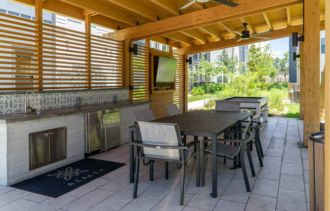 A patio with a table and chairs and a fireplace.