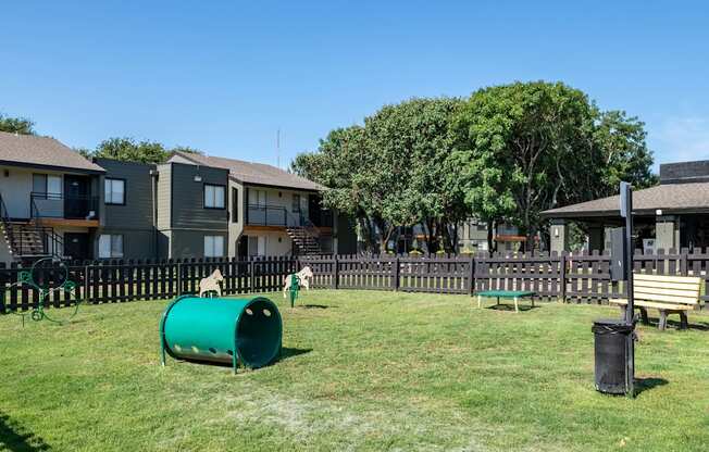 Large dog park at Fusion Fort Worth apartment complex in Haltom City, TX with grey picket fence and green lawn