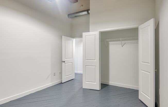an empty room with white doors and a closet