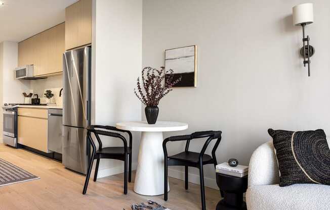 a living room with a small table and a kitchen at The Paxton, Brooklyn, 11201