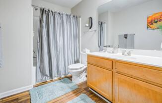 Full bathroom with double vanity, toilet, and garden tub at Westmont Commons apartments for rent