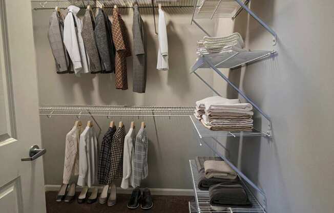 A hallway with a white door and a rack of ties and shirts.