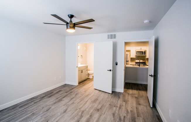 a bedroom with hardwood floors and white walls