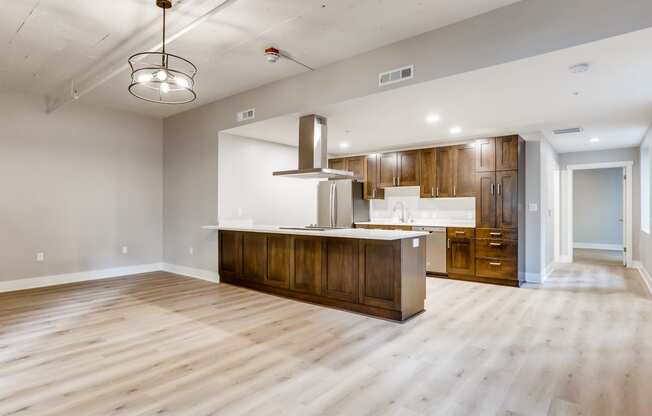 an open kitchen and living room with wood flooring and a kitchen island with wood