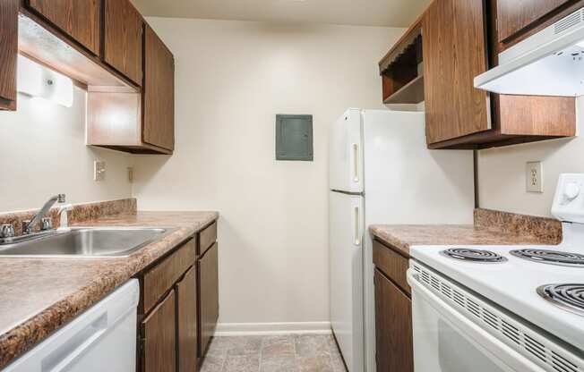 a kitchen with white appliances and wooden cabinets and a white refrigerator