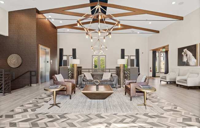 A large, open living room with a wooden floor and a chandelier hanging from the ceiling.