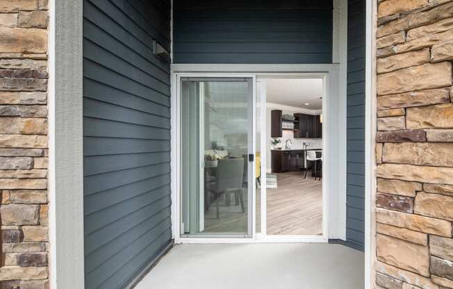 an open door leading to a kitchen and dining area