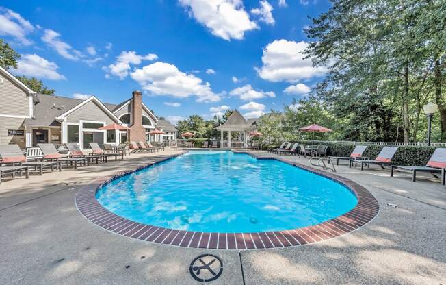 a resort style pool with chairs around it and houses in the background