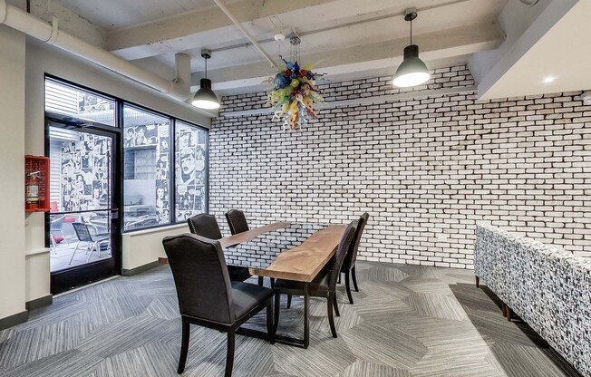 a dining room with a table and chairs and a brick wall