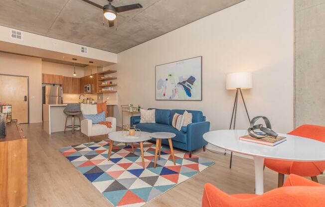A living room with a white table and a blue couch.